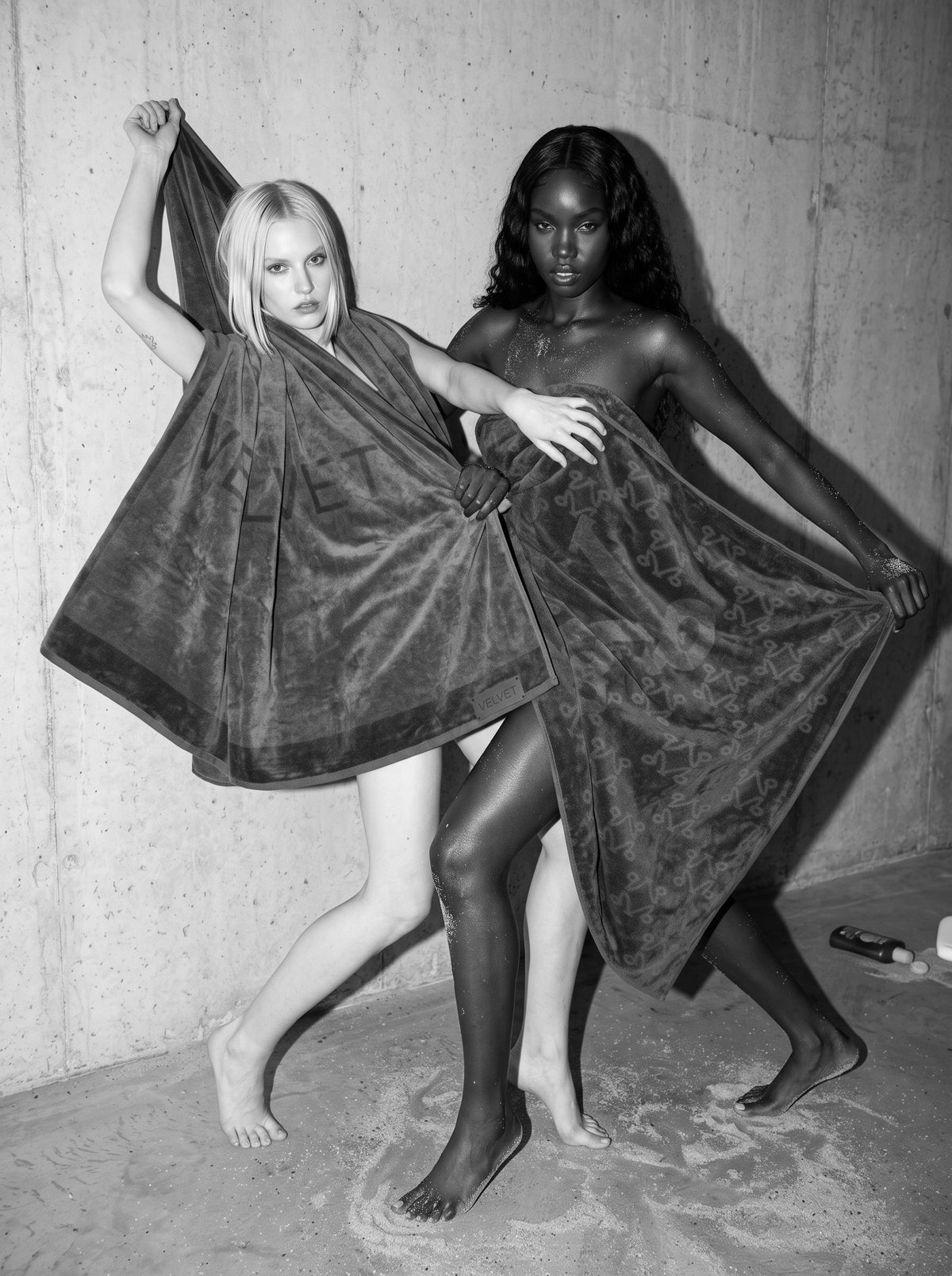 Two women holding VELVET towels open, black and white