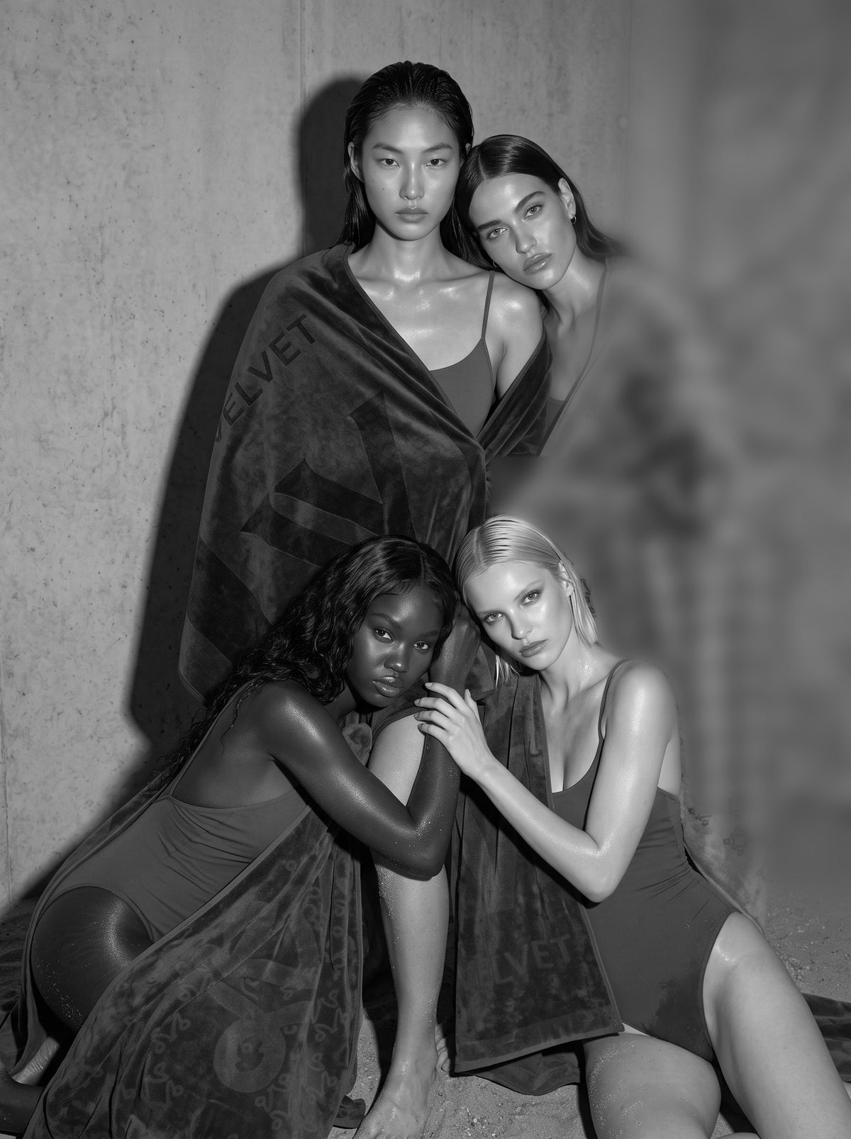 Four women gathered in VELVET towels against stone, black and white